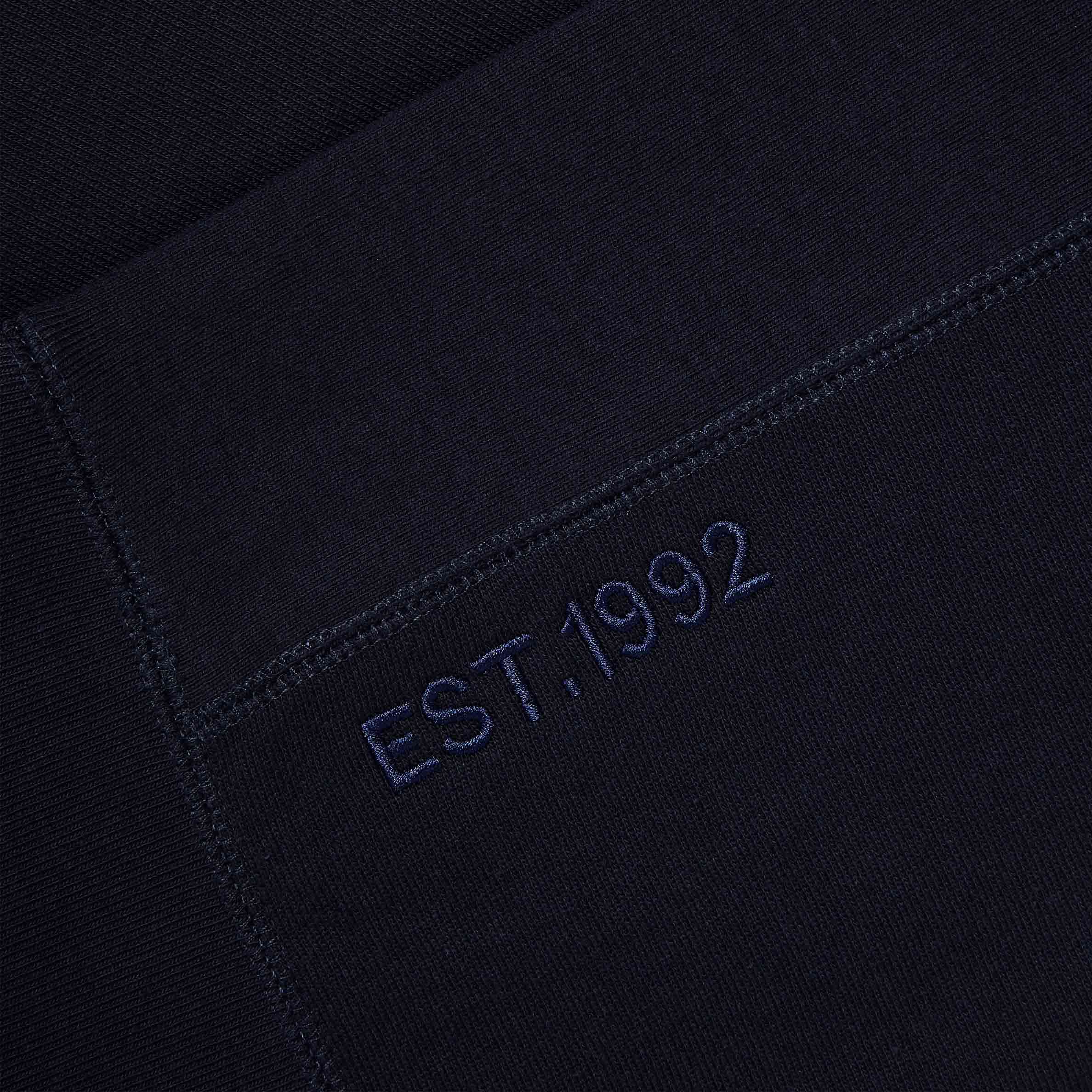 Close-up of ‘EST. 1992’ embroidery on Lanzera Club Hoodie in Navy Clásico.