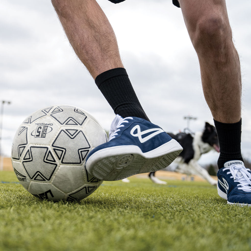 A player using Lanzera Jackal Navy shoes to control a soccer ball, highlighting the futsal-ready traction, precise touch, and non-marking outsole designed for quick movements.