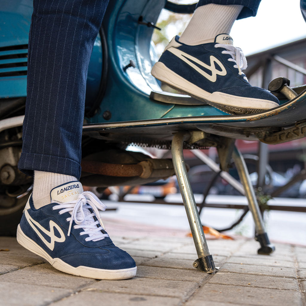 Lanzera Jackal Navy suede shoes worn while stepping onto a classic scooter, blending heritage football-inspired design with modern street style.